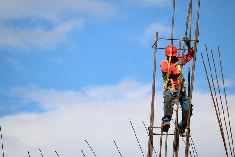 Construction worker climbing reinforcement bars