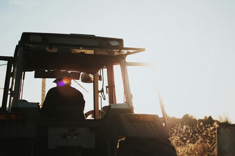 Farmer on a tractor at sunset